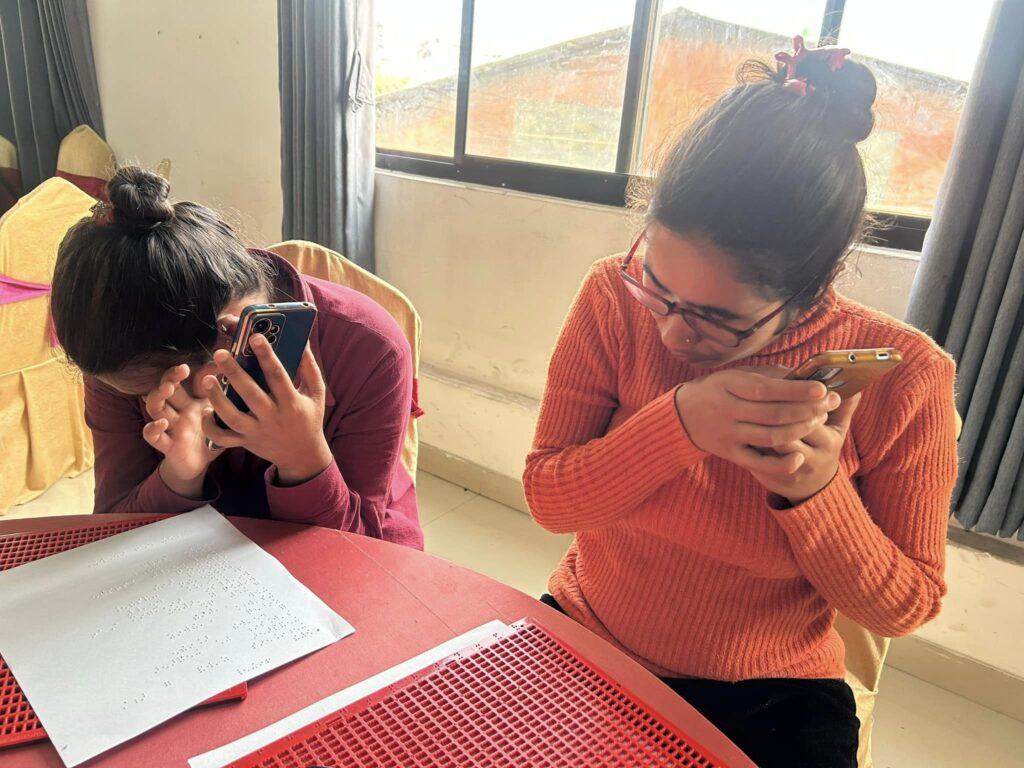 Two participants following the tips given by the facilitator using their mobile phones.